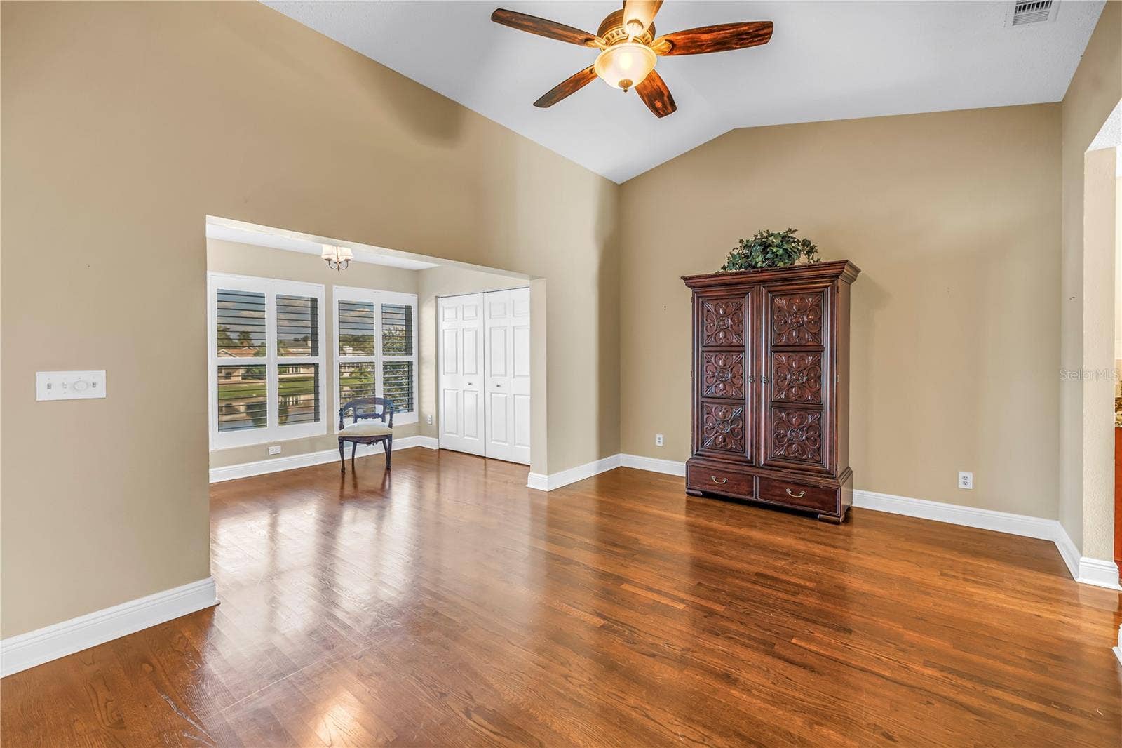 868 GLADES COURT NE, St Petersburg, FL 33702 Spacious primary bedroom featuring vaulted ceilings and an elegantly enclosed porch with two additional closets. This room offers magnificent lake views and provides an ideal space for a home gym, a quiet reading nook, or a nursery.