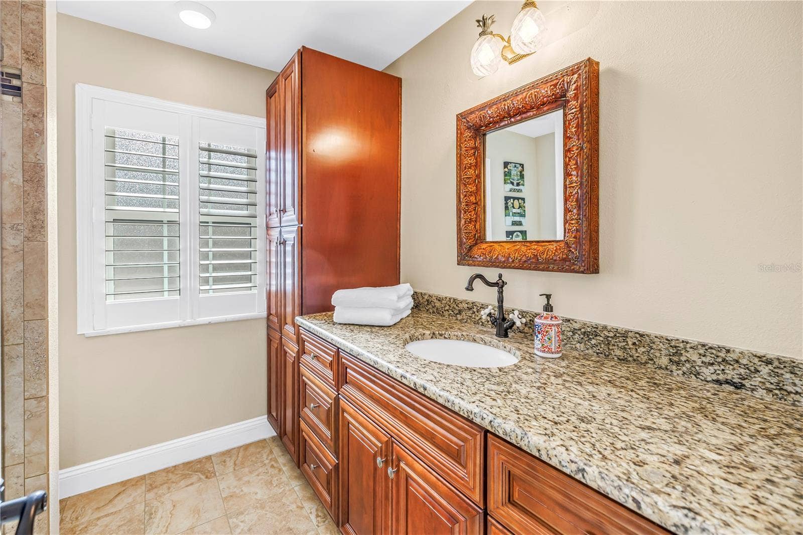 868 GLADES COURT NE, St Petersburg, FL 33702 Primary bathroom featuring a second granite vanity, ample storage cabinetry, and custom-built fixtures.