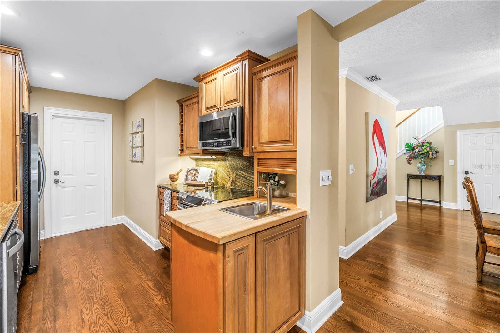 868 GLADES COURT NE, St Petersburg, FL 33702 The kitchen features an efficient workspace equipped with a range, a convection microwave, and a preparation sink with an integrated butcher block countertop.