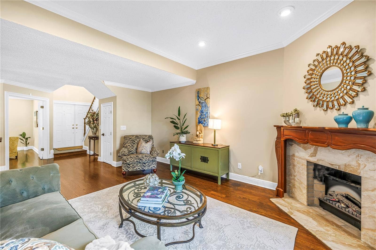868 GLADES COURT NE, St Petersburg, FL 33702 The open formal living area provides an ideal entry for guests, featuring panoramic lake views and an elegant marble fireplace.