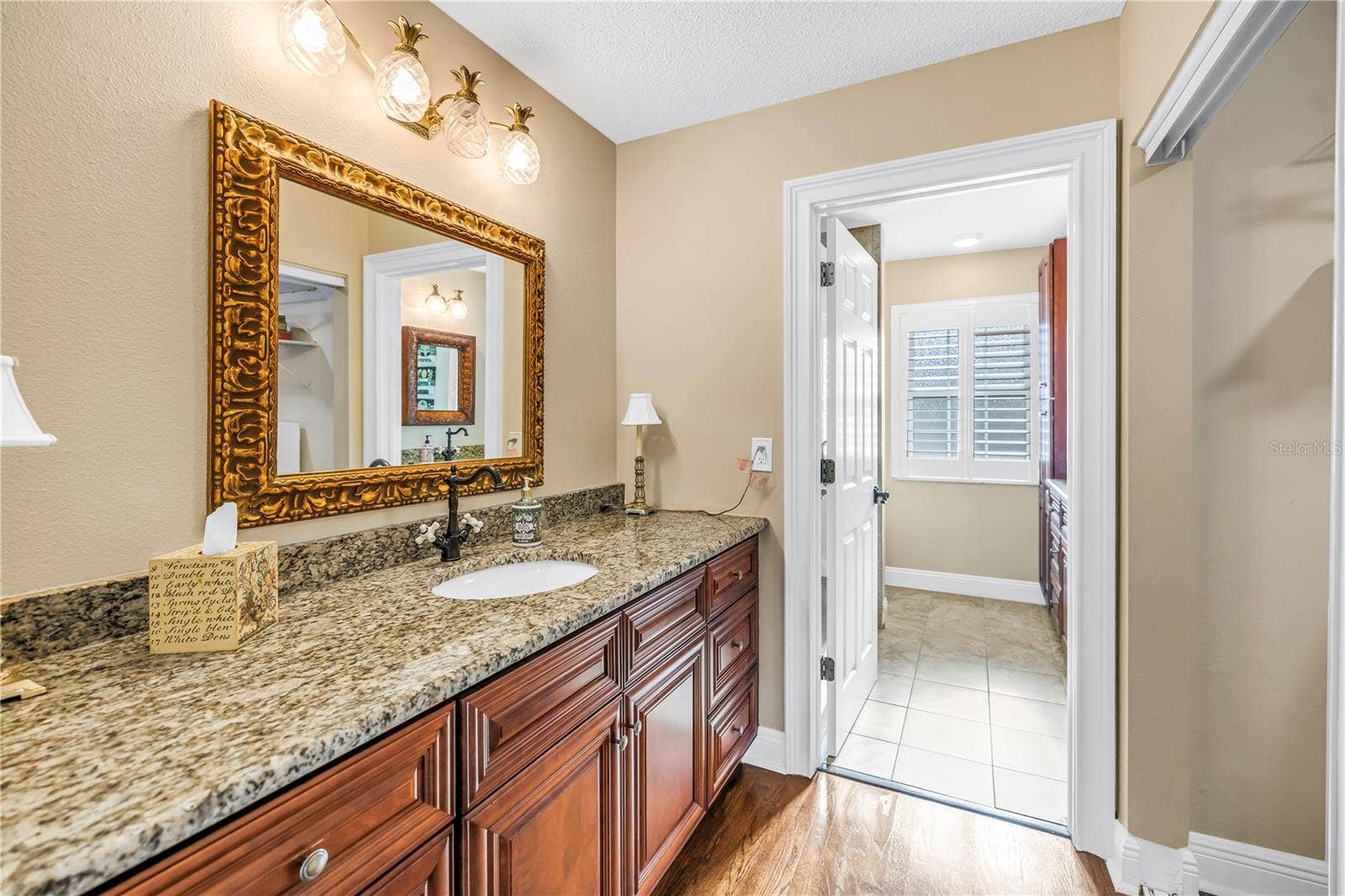 868 GLADES COURT NE, St Petersburg, FL 33702 The primary bathroom features high-quality custom solid wood cabinetry, granite countertops, and elegant lighting and bath fixtures.