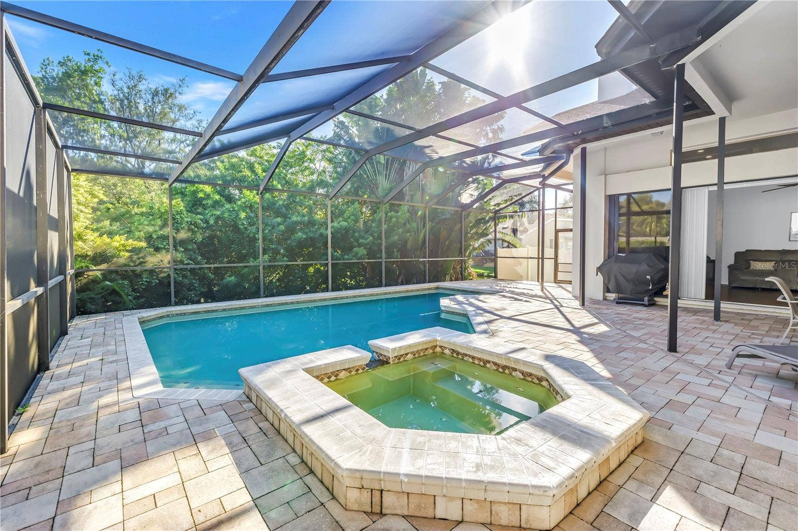 1186 GASPARILLA DRIVE NE, St Petersburg, FL 33702 This property features a propane-heated hot tub and a spacious pool, all fully enclosed and protected by a massive screened lanai, creating a true luxury oasis.