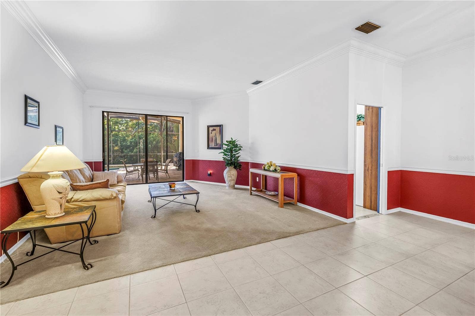 1186 GASPARILLA DRIVE NE, St Petersburg, FL 33702 Open concept front room and entry foyer offering an immediate view of the pool oasis through wide 8-ft sliding glass doors set under expansive 10-ft ceilings. SEE VIRTUAL RENDERING IN PHOTO 54
