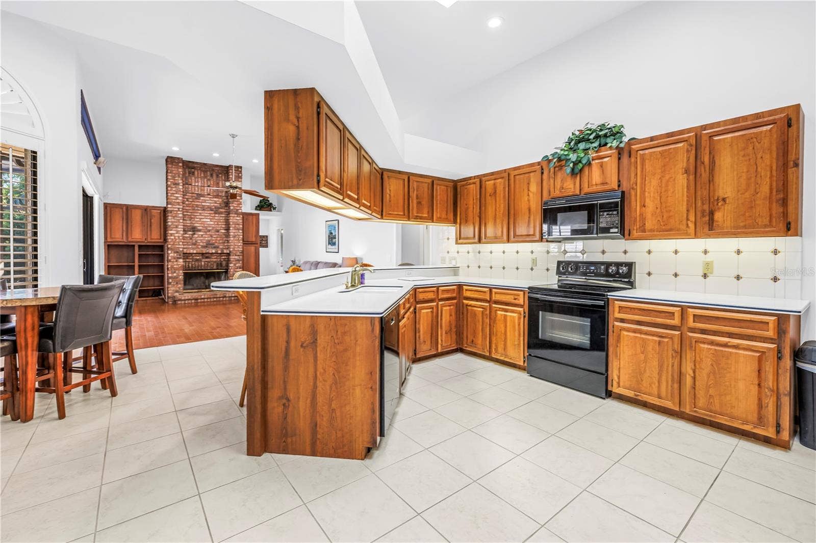 1186 GASPARILLA DRIVE NE, St Petersburg, FL 33702 Open Concept Kitchen Great Room with soaring 12-Foot Ceilings and wood burning fireplace. SEE VIRTUAL RENDERING IN PHOTO 56