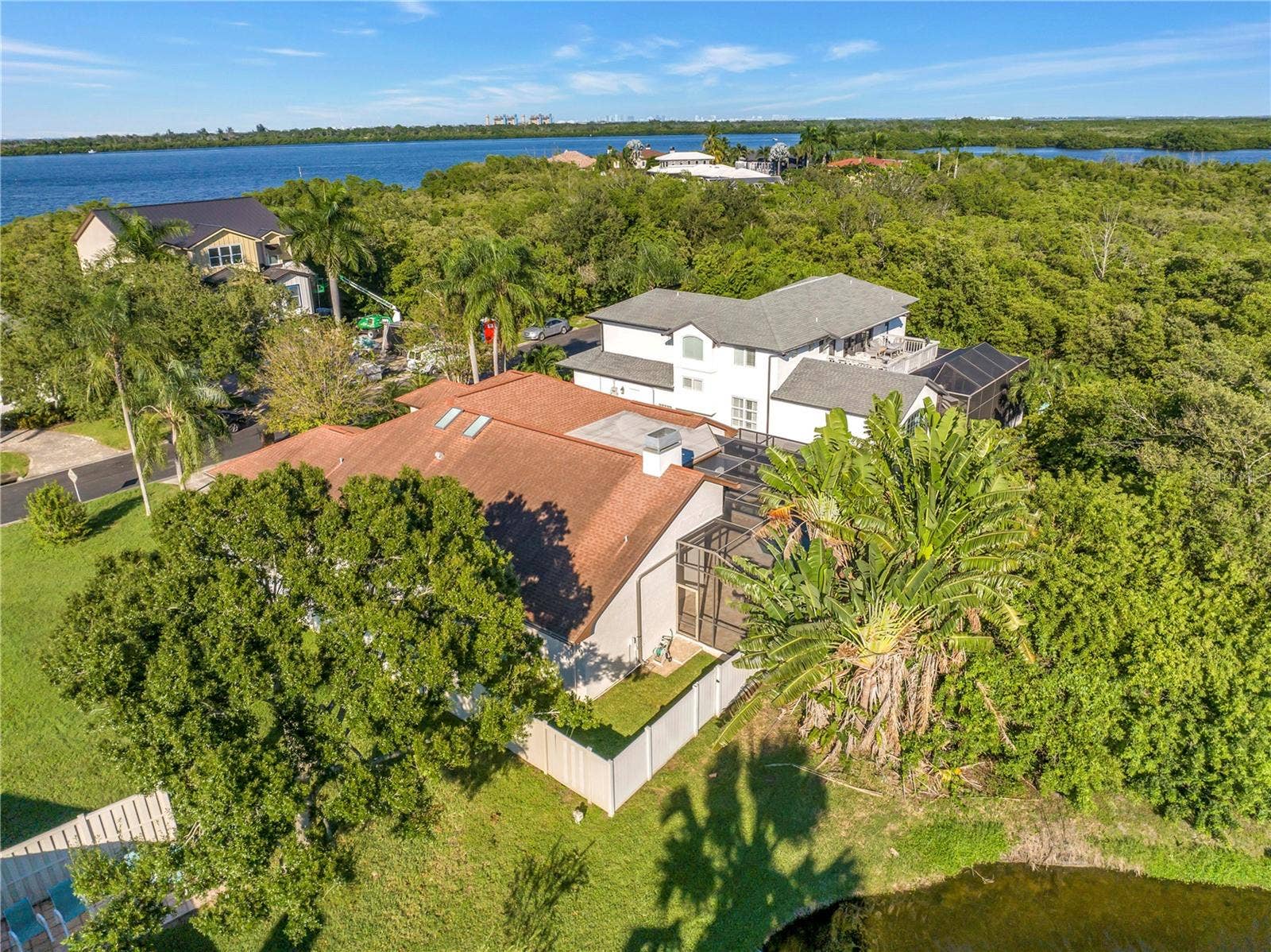 1186 GASPARILLA DRIVE NE, St Petersburg, FL 33702 The back corner of the lot features a scenic view of a neighborhood pond, currently enclosed by a private fence.