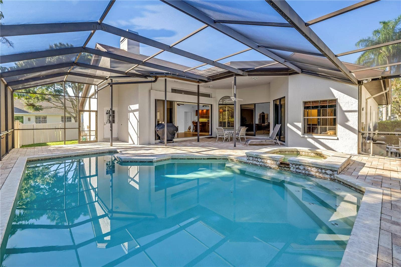 1186 GASPARILLA DRIVE NE, St Petersburg, FL 33702 This backyard oasis features in-pool seating and expansive open space under the screened lanai. The design seamlessly integrates the interior living area with the outdoors while maintaining complete privacy.