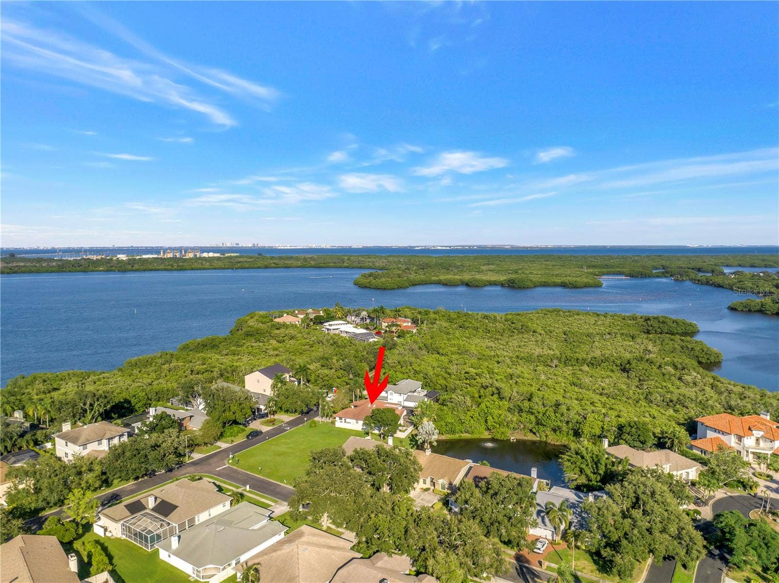 1186 GASPARILLA DRIVE NE, St Petersburg, FL 33702 Captures a scenic view of Riviera Bay looking north, with the City of Tampa visible in the distance. This home is ideally situated for easy commuting, offering convenient access to downtown Tampa in approximately 15 minutes.