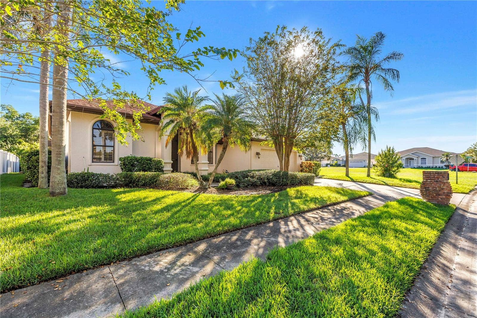 1186 GASPARILLA DRIVE NE, St Petersburg, FL 33702 Charming exterior featuring sidewalks, a two-car driveway, and a two-car garage. Located in the beautiful Caya Costa nature preserve, perfect for safe, peaceful strolls at any time of day or night.