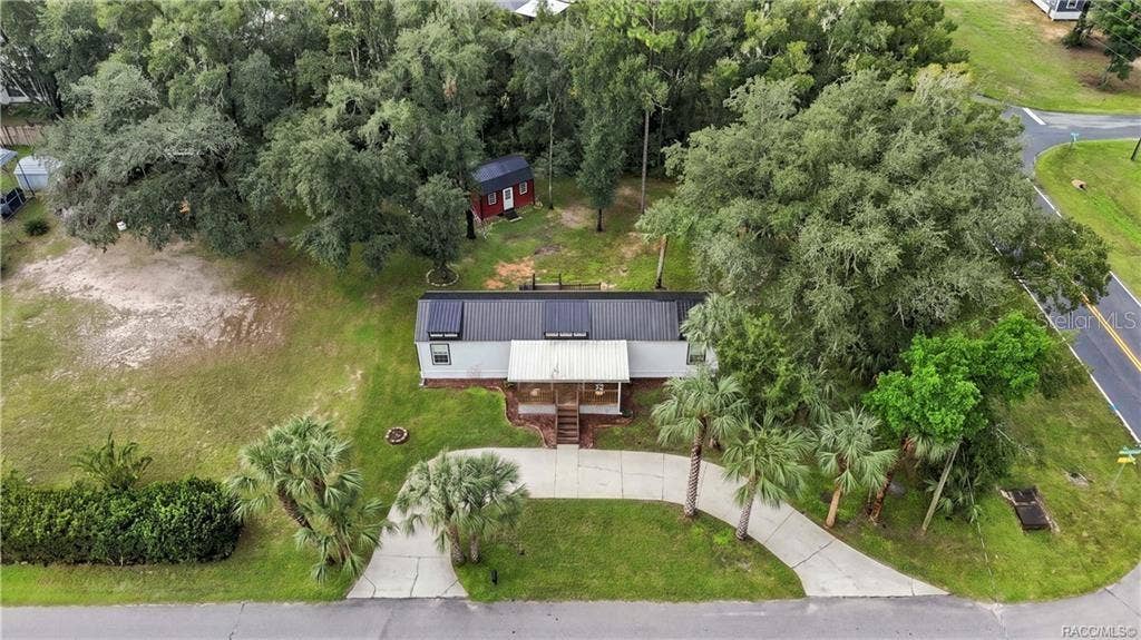 6230 W GLEN ROBBIN COURT, Crystal River, FL 34429 Aerial Property View A beautiful overhead perspective of the .29-ACRE CORNER HOMESITE, showcasing the METAL ROOF, COVERED FRONT PORCH, circular concrete driveway, mature trees & detached storage building.