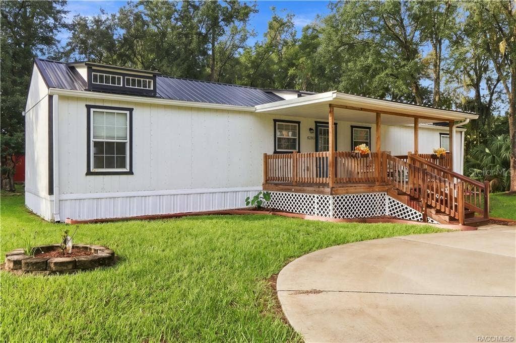 6230 W GLEN ROBBIN COURT, Crystal River, FL 34429 Front Exterior Attractive white exterior w/contrasting dark trim, METAL ROOF & spacious covered wooden porch, surrounded by a lush green lawn.