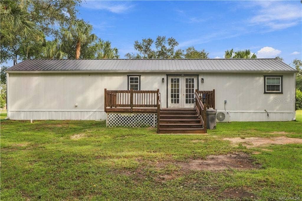 6230 W GLEN ROBBIN COURT, Crystal River, FL 34429 Rear Exterior Attractive rear elevation featuring the METAL ROOF, French doors, wooden deck w/steps & a MINI-SPLIT HEATING & COOLING SYSTEM.
