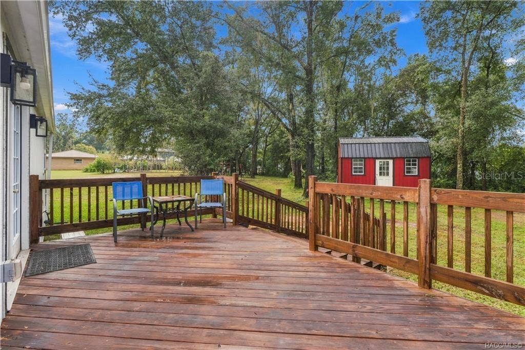 6230 W GLEN ROBBIN COURT, Crystal River, FL 34429 Rear Deck Step outside & enjoy the spacious WOODEN REAR DECK overlooking the backyard! A wonderful spot for morning coffee, outdoor conversation or relaxing beneath the surrounding trees.