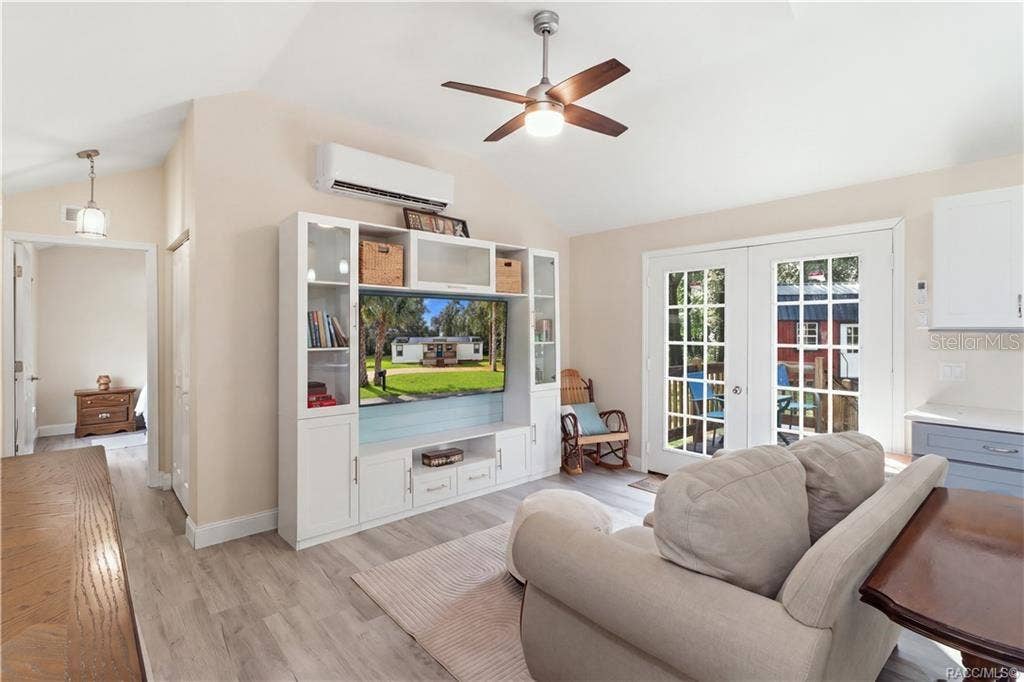 6230 W GLEN ROBBIN COURT, Crystal River, FL 34429 Open Living Area Another beautiful view of the comfortable living room, showcasing the open layout, attractive furnishings, w/ entertainment center & French doors leading outdoors.