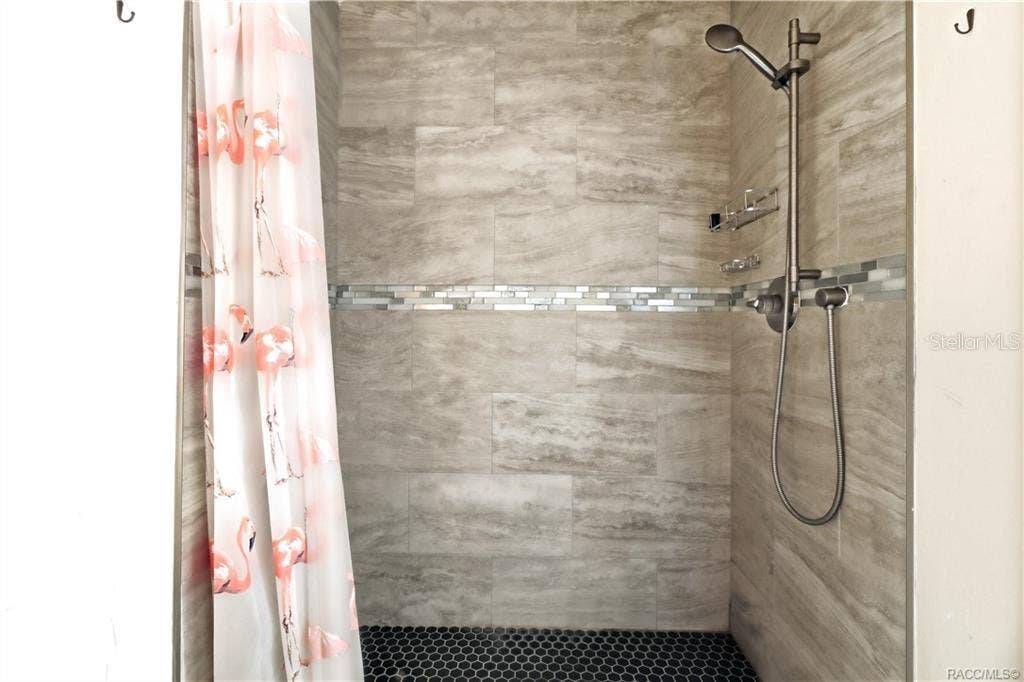 6230 W GLEN ROBBIN COURT, Crystal River, FL 34429 Tiled Walk-In Shower Beautifully finished WALK-IN SHOWER featuring floor-to-ceiling tile, decorative mosaic accent band, pebble-style shower flooring & handheld showerhead.