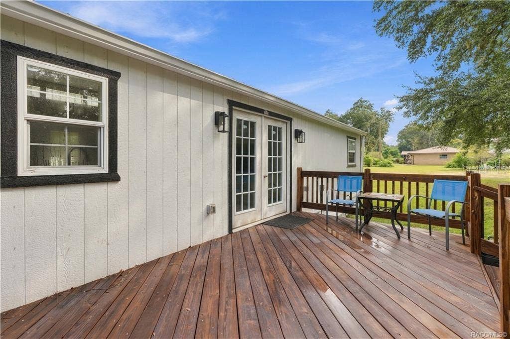 6230 W GLEN ROBBIN COURT, Crystal River, FL 34429 Outdoor Living Another view of the rear deck showcasing its open layout, wooden railings & easy access to the backyard. A great setting for enjoying Florida's beautiful weather!
