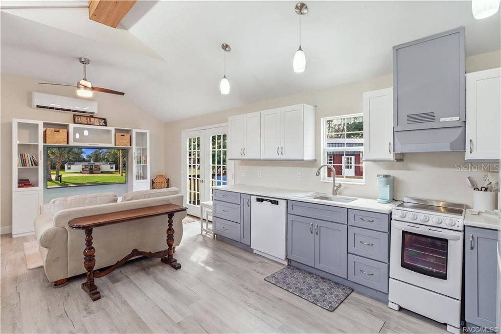 6230 W GLEN ROBBIN COURT, Crystal River, FL 34429 Kitchen & French Doors Bright kitchen featuring white upper cabinetry, soft blue-gray lower cabinetry, SOLID SURFACE COUNTERTOPS & French doors leading to the outdoor deck.