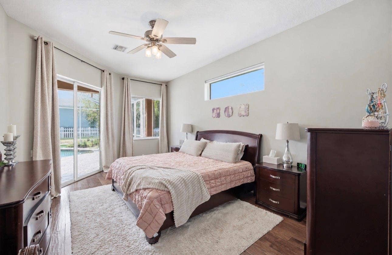 Primary Suite with sliders out to the pool area, high ceilings, huge walk in closet, huge bathroom, and storage.