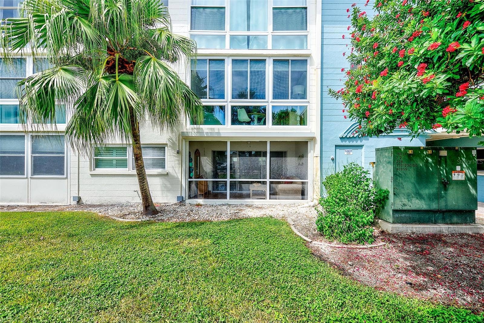 6201 2ND STREET E, #74, St Pete Beach, FL 33706 Exterior photo of the screen porch. Electric storm shutter is attached