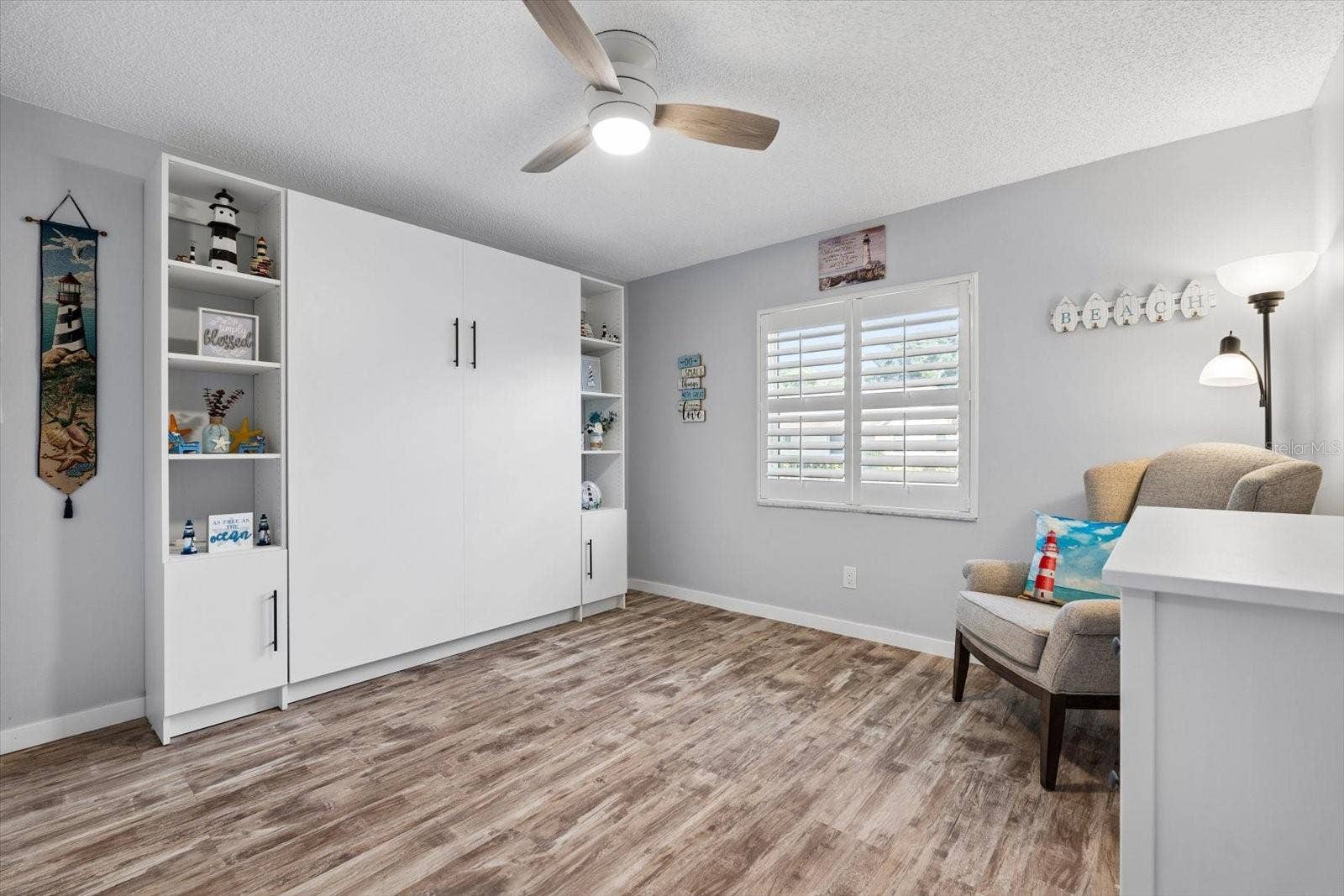 Second bedroom with murphy bed (conveys with home).  Plantation shutters and large closet.