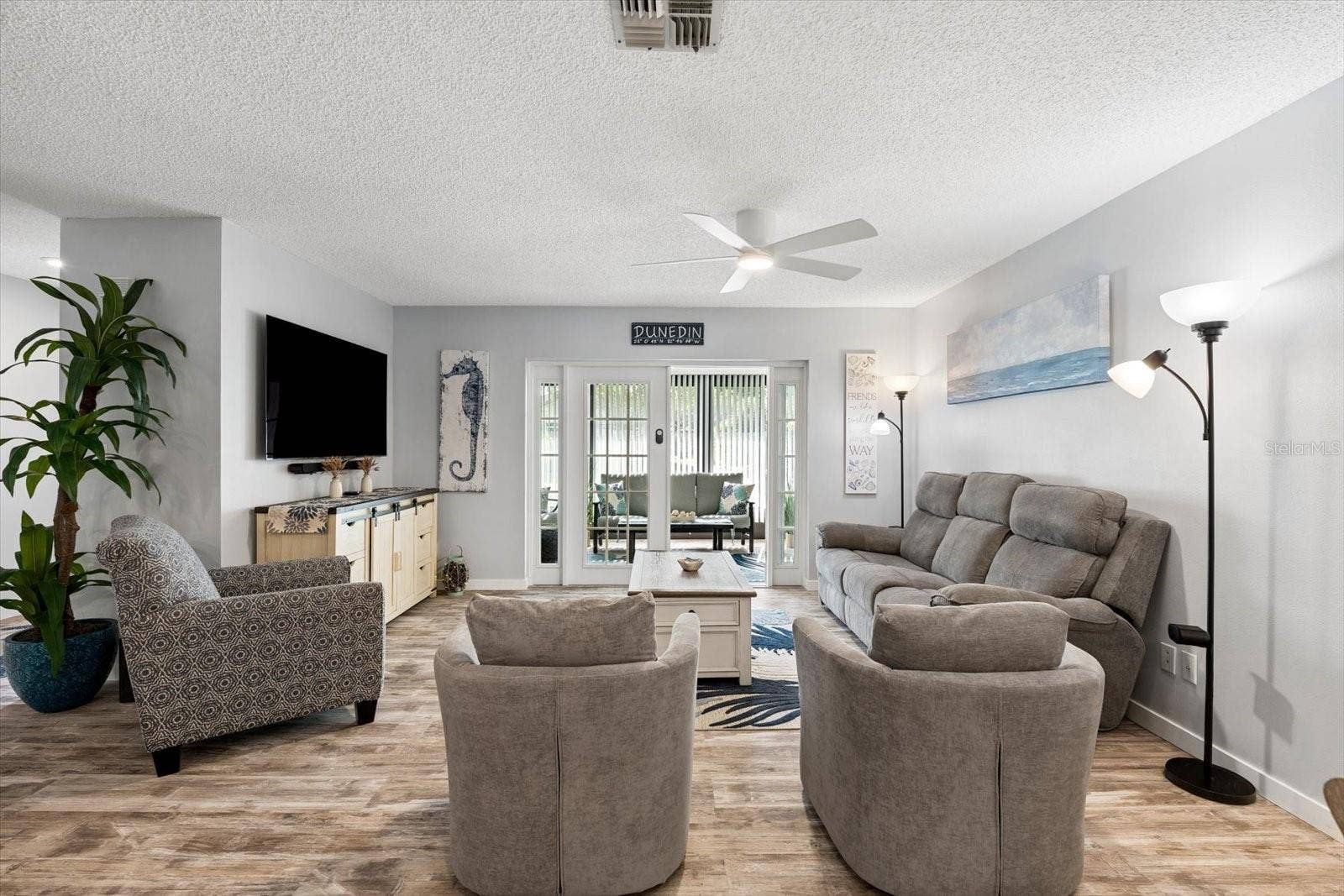 Living room with LVP flooring opens to enclosed Lanai