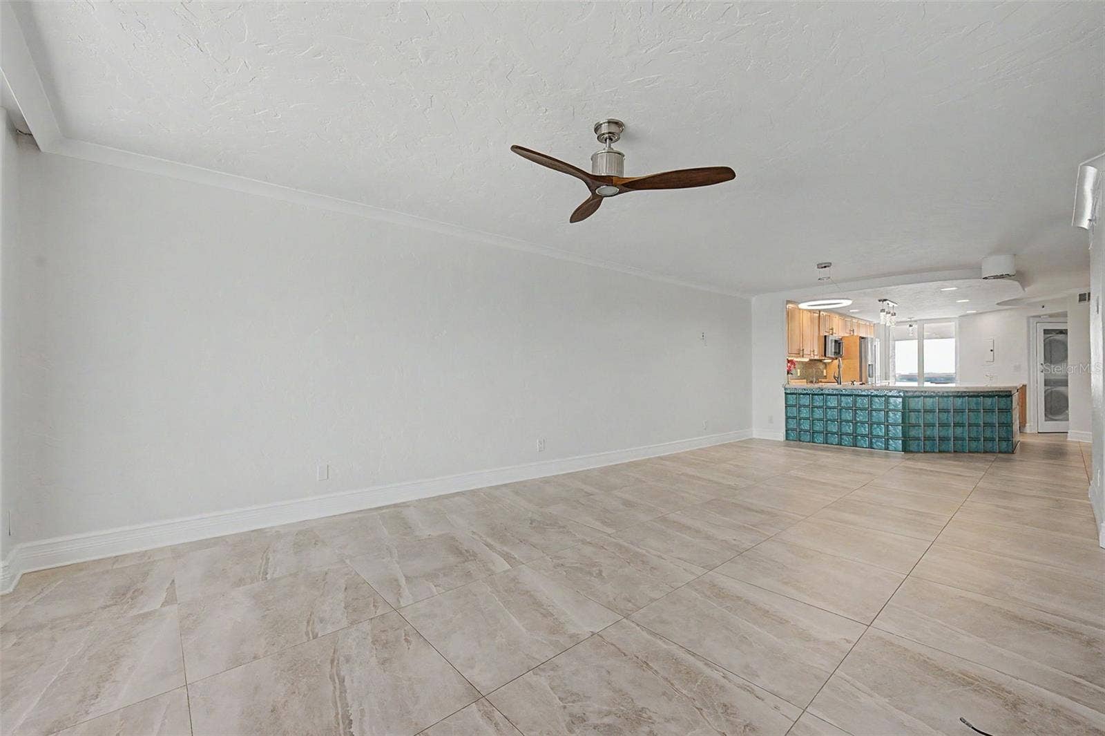 Step back in from the balcony to the Living area and looking into the kitchen.
