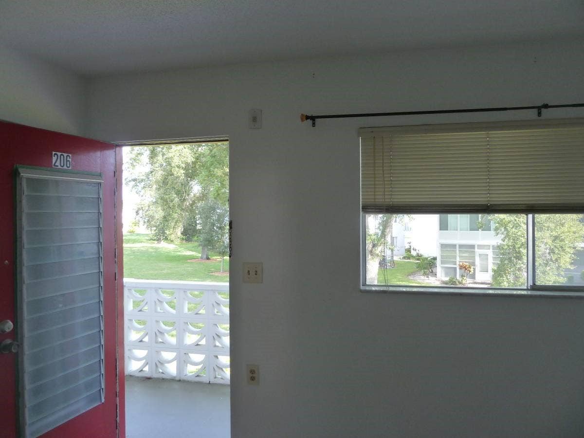 8425 112TH STREET, #206, Seminole, FL 33772 Bedroom exterior door to balcony overlooking parkway