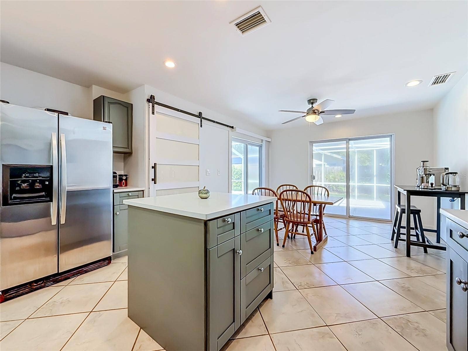 1852 SOURWOOD BOULEVARD, Dunedin, FL 34698 Kitchen - Dining Room - Outdoor Living and Pool Area
