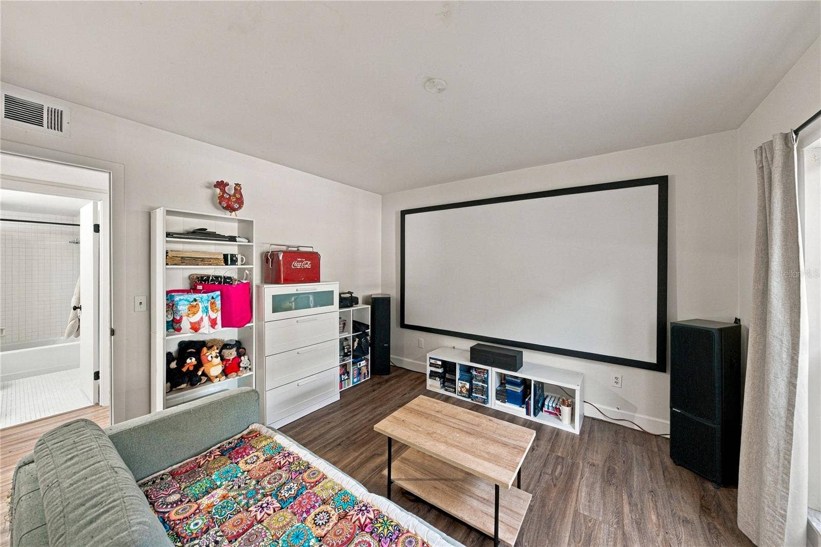 Second Bedroom used as a Movie Room with Plank Flooring and Large Closet