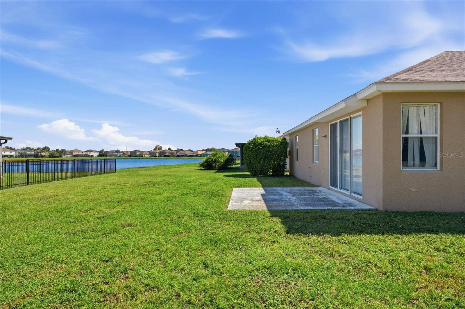 Rear patio and open lawn with pond view