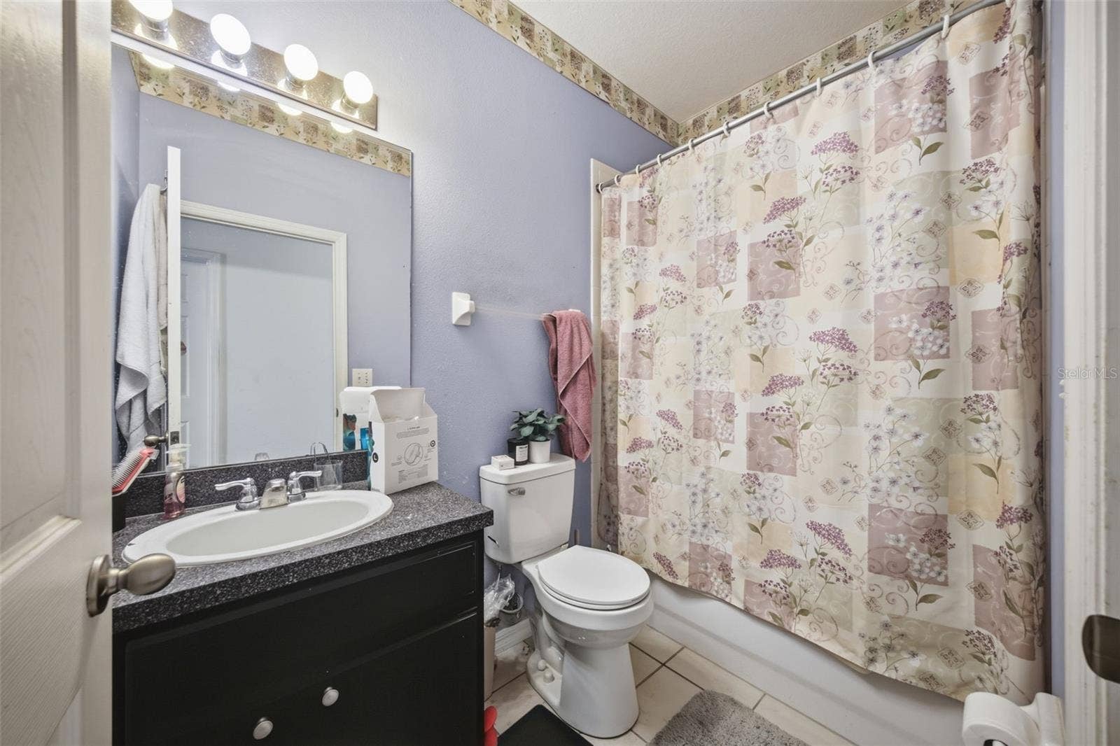 Hall bath with single vanity, tub/shower combo and tile floor
