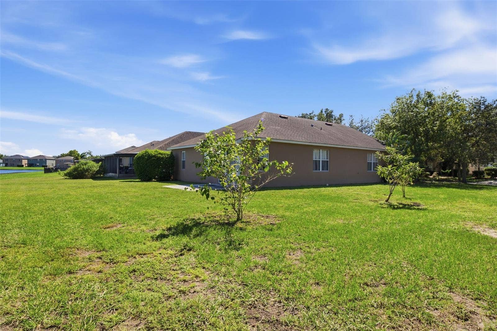 Spacious side and rear lawn with young trees