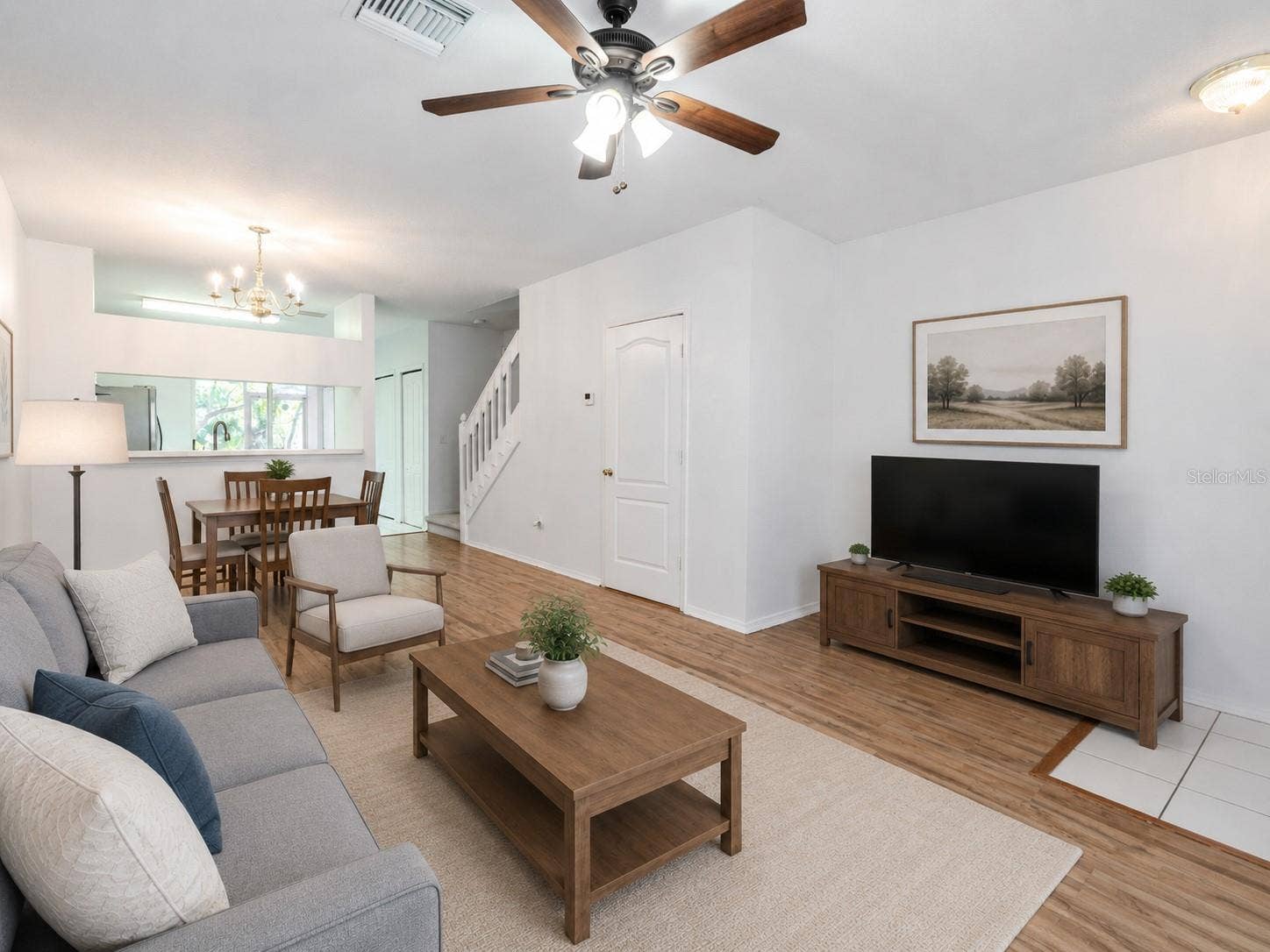 2432 LAKE WOODBERRY CIRCLE, Brandon, FL 33510 The Living room features neutral tones, wood laminate flooring, a ceiling fan with light kit and picture window.
