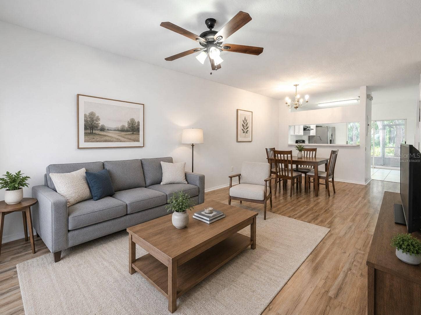 2432 LAKE WOODBERRY CIRCLE, Brandon, FL 33510 The Living room features neutral tones, wood laminate flooring, a ceiling fan with light kit and picture window. (Photo has been virtually staged.)