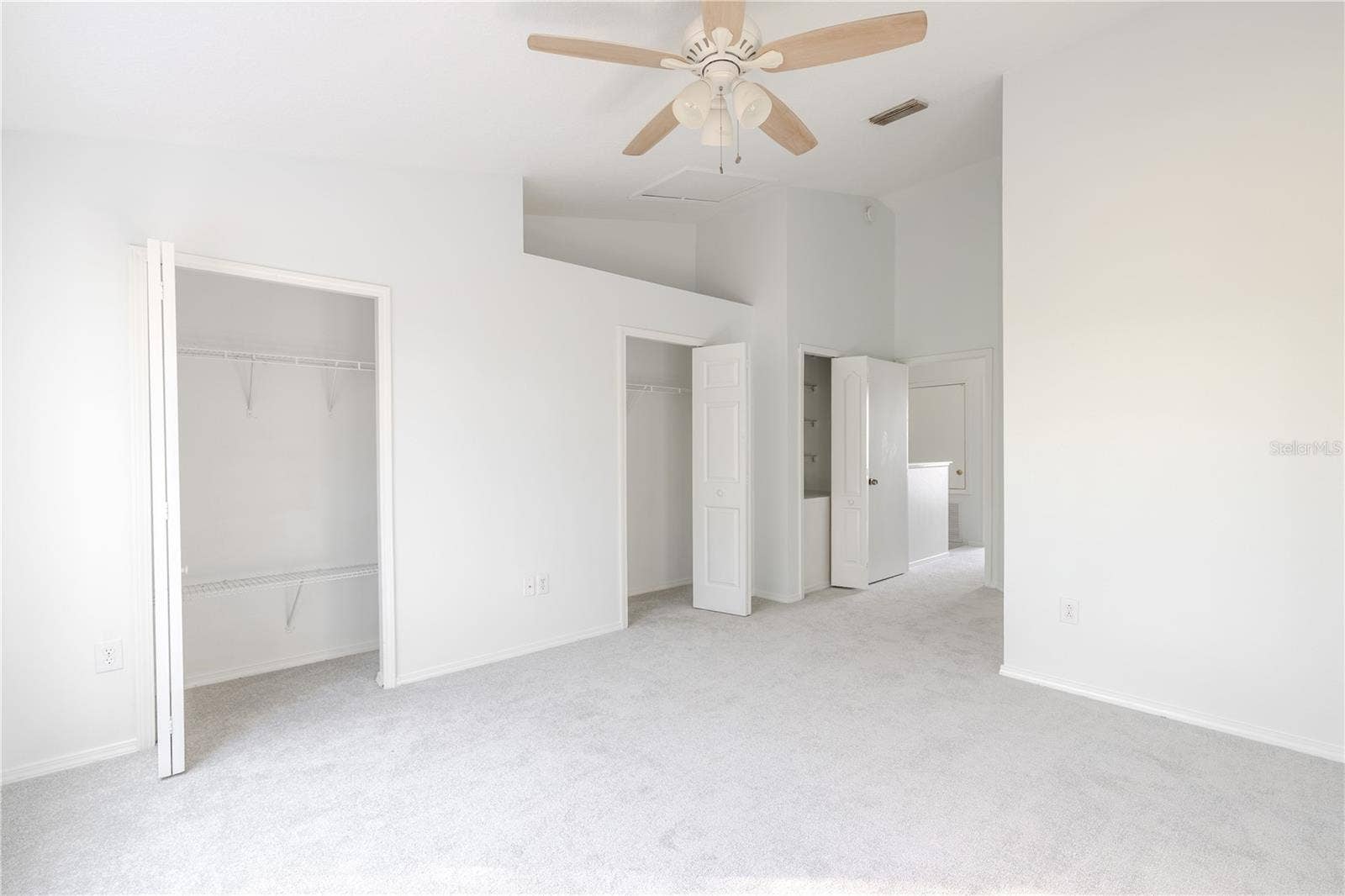2432 LAKE WOODBERRY CIRCLE, Brandon, FL 33510 The Primary bedroom features neutral tone walls and carpet, a ceiling fan with light kit and vaulted ceiling.