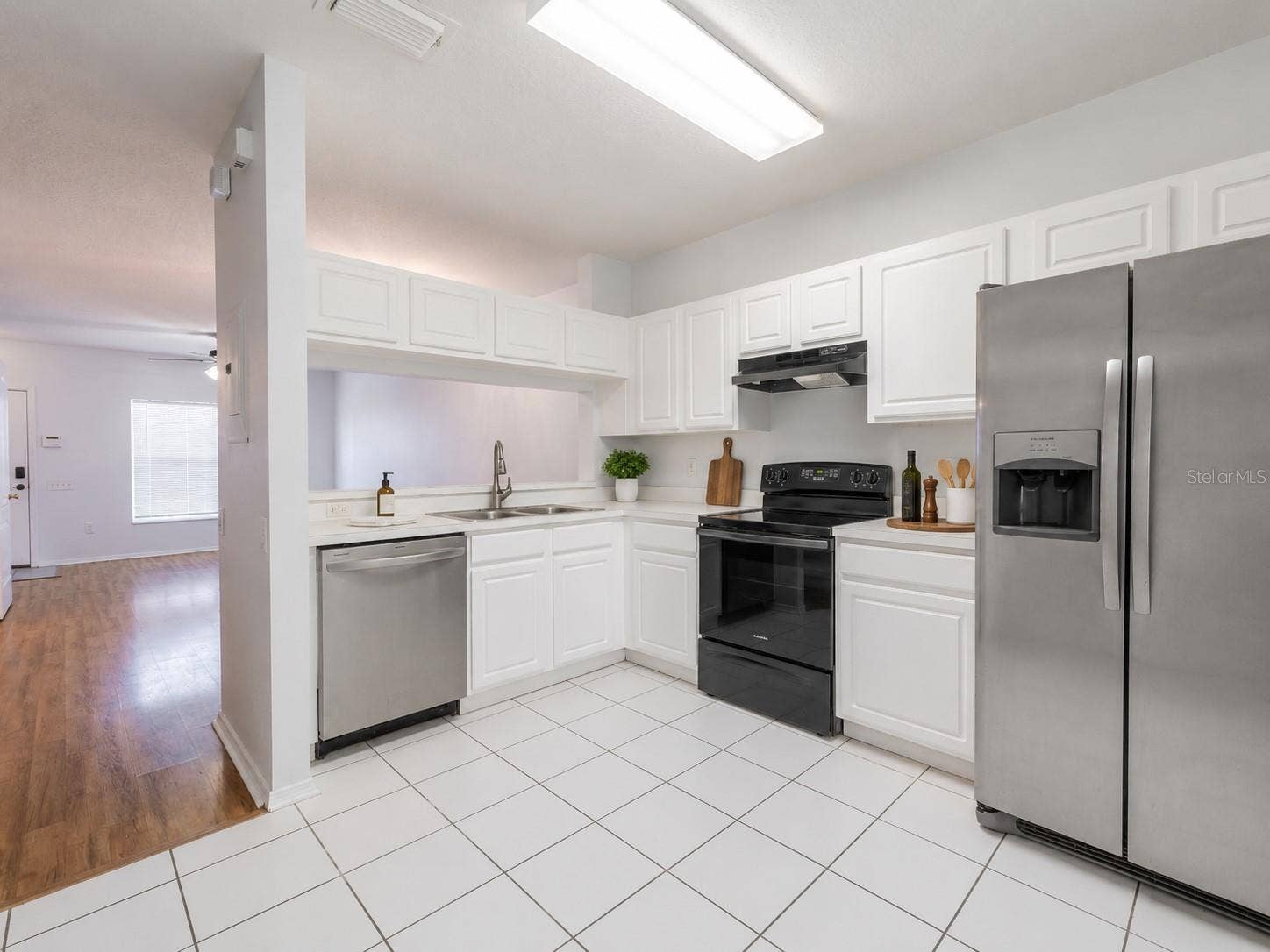 2432 LAKE WOODBERRY CIRCLE, Brandon, FL 33510 Kitchen features ceramic tile flooring, stainless steel appliances including a French door refrigerator with ice maker and water dispenser, an electric range and sliding glass door to the private screened in patio.