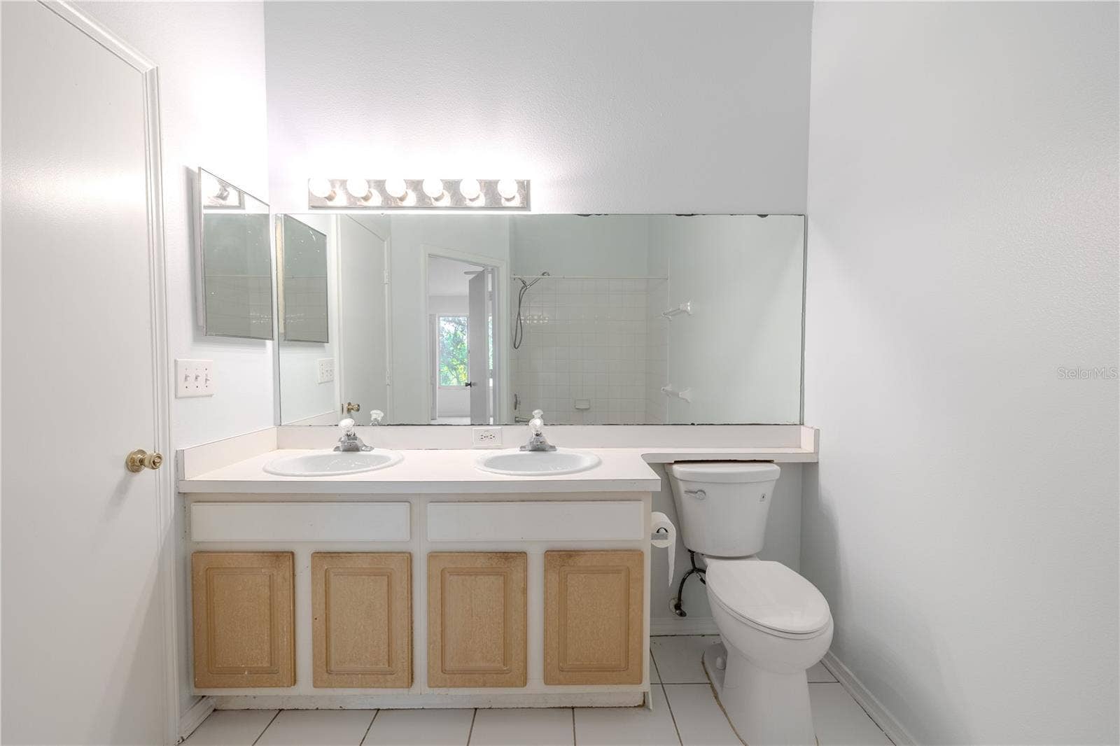 2432 LAKE WOODBERRY CIRCLE, Brandon, FL 33510 Shared 2nd floor bathroom features a mirrored vanity with dual sinks and storage, ceramic tile floor and a tub with shower.