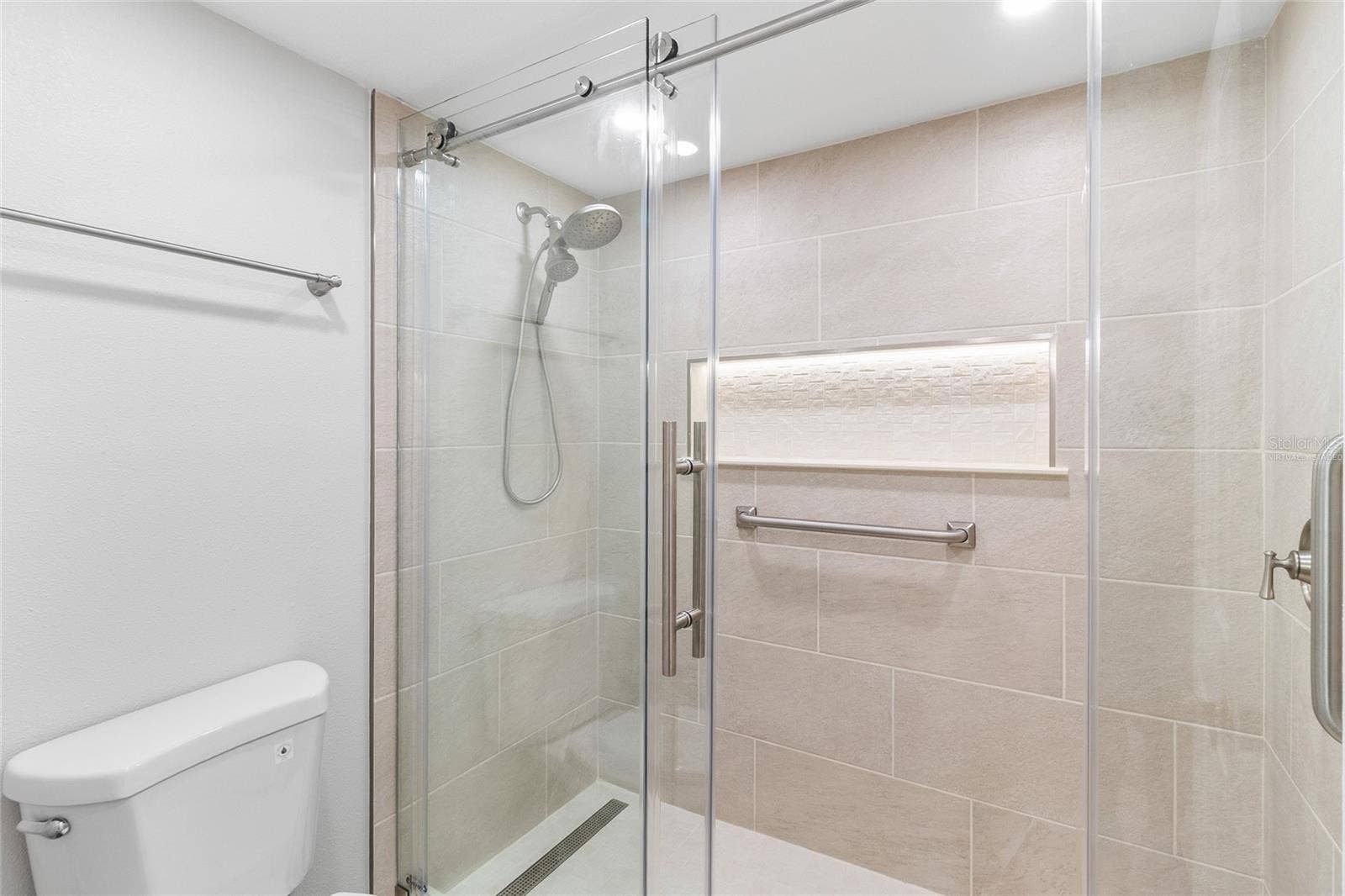 2980 HAINES BAYSHORE ROAD, #105, Clearwater, FL 33760 VIRTUALLY STAGED primary bath with updated tile and enclosure