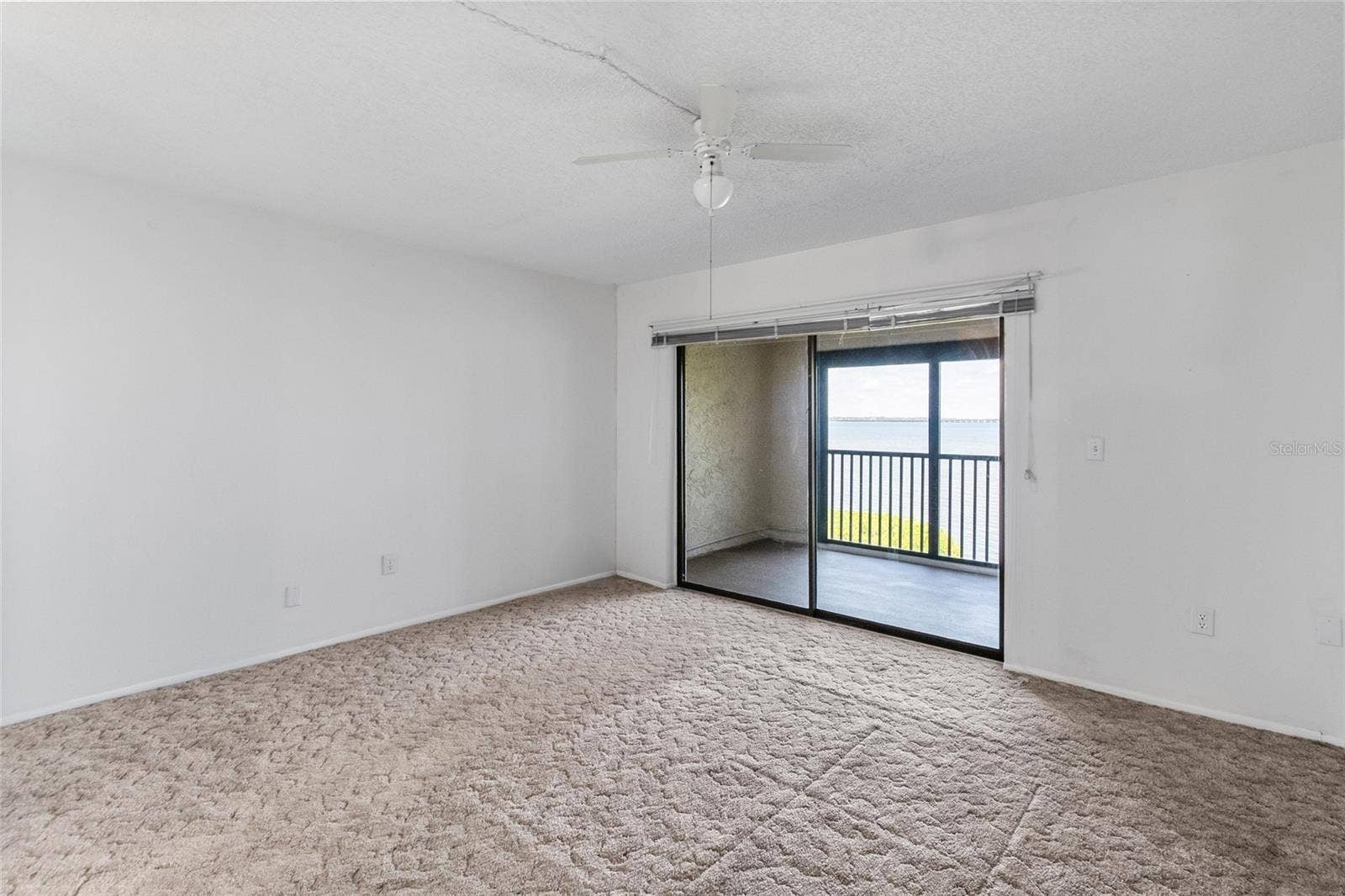 2980 HAINES BAYSHORE ROAD, #105, Clearwater, FL 33760 Primary bedroom - looking towards the private balcony with panoramic water views.