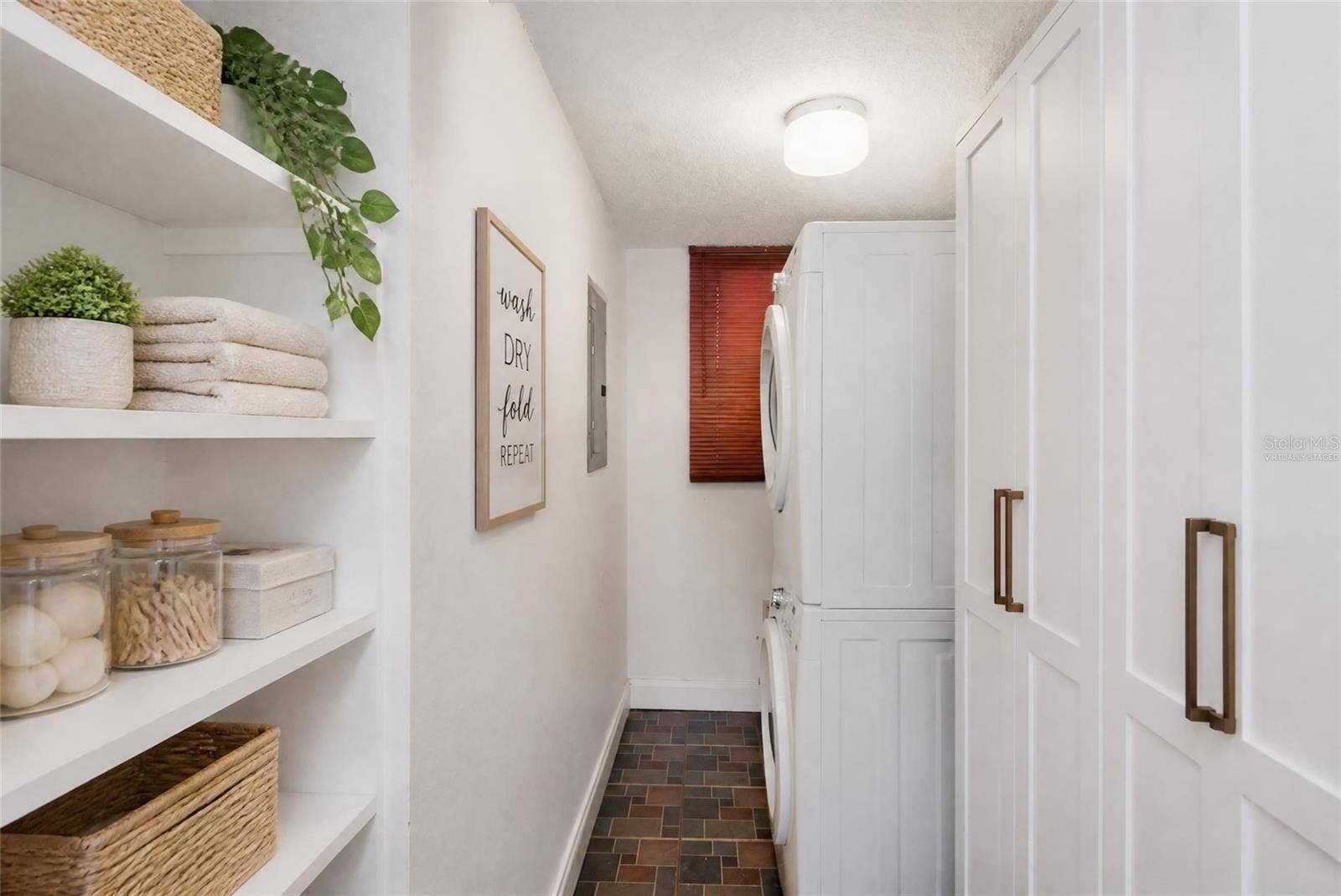 2980 HAINES BAYSHORE ROAD, #105, Clearwater, FL 33760 Virtually Staged - Laundry room - shelved added and HVAC enclosed in cabinets.