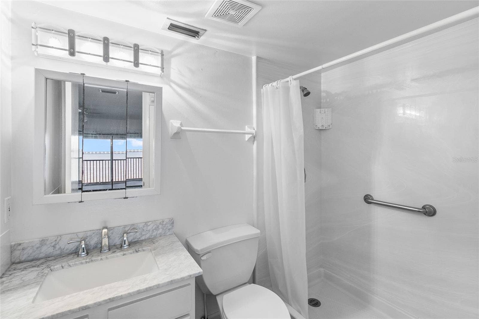 2980 HAINES BAYSHORE ROAD, #105, Clearwater, FL 33760 Primary bath with step in shower - water view seen in mirror