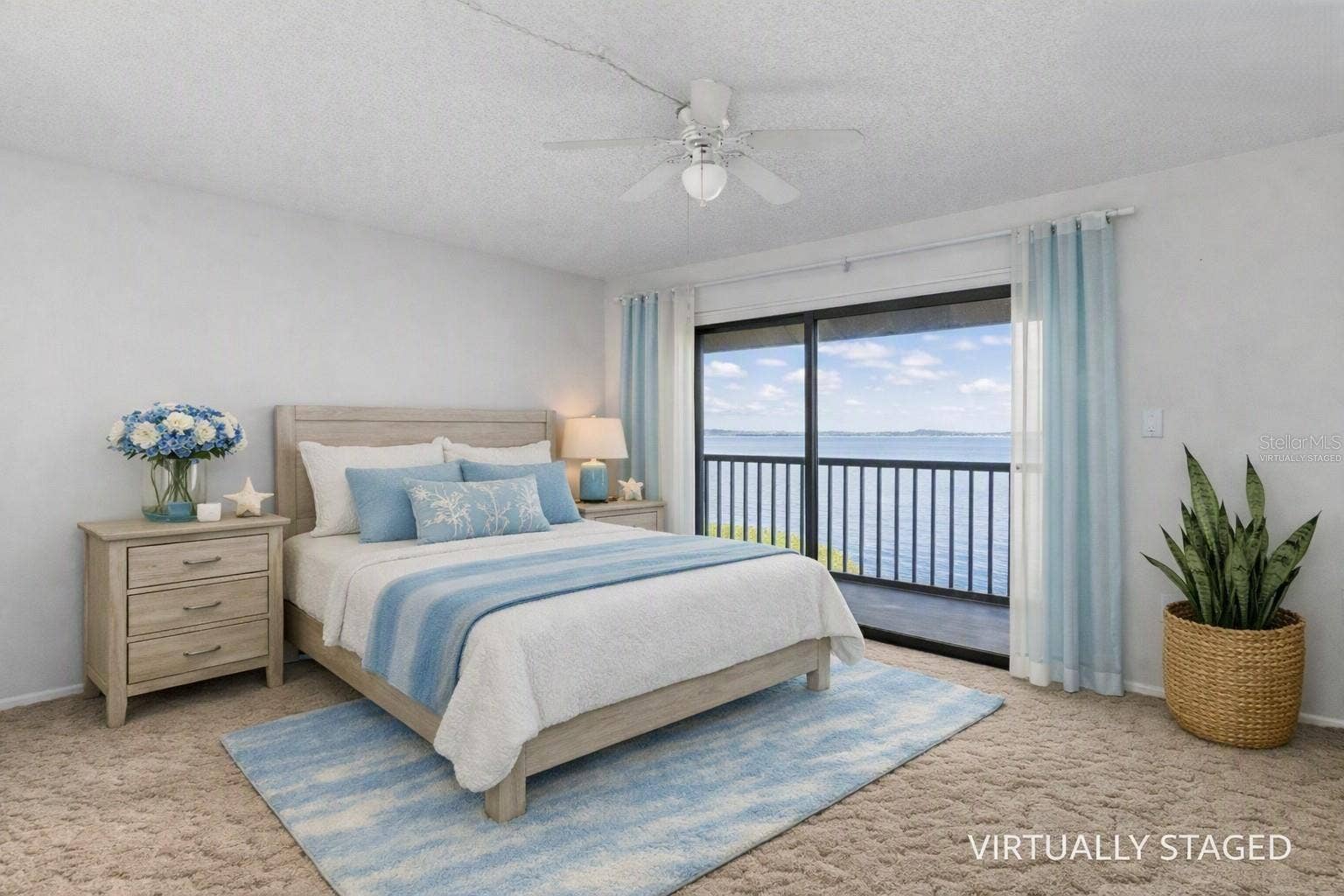 2980 HAINES BAYSHORE ROAD, #105, Clearwater, FL 33760 Virtually staged primary bedroom looking towards the balcony and fully panoramic water views.