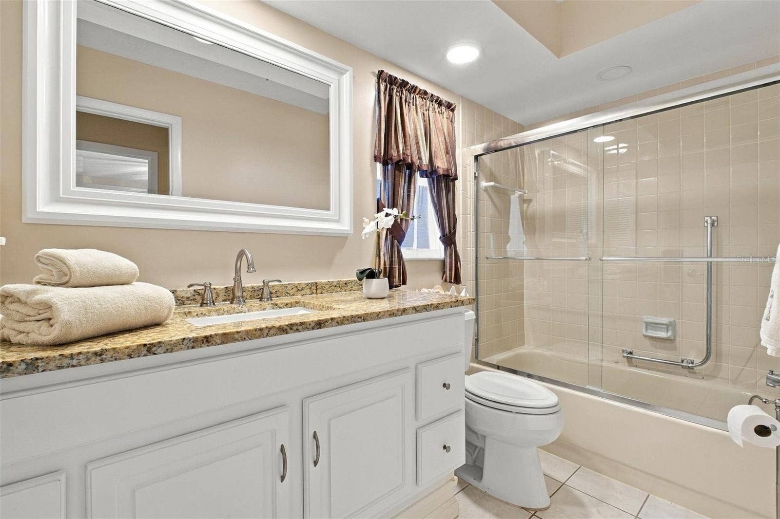 Beautifully updated hall bath with newer oversized vanity with stone top, mirror, recessed lighting, and tub/shower combo~