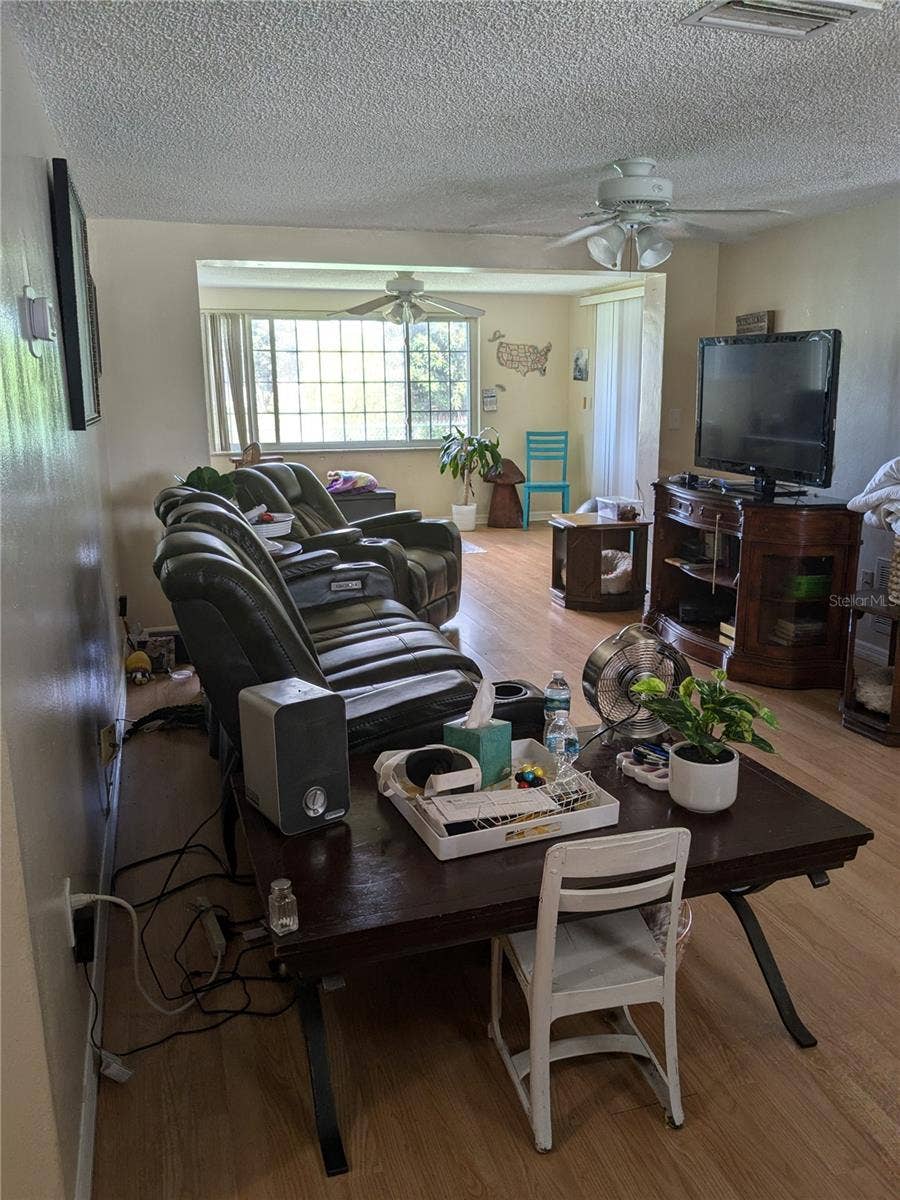 3937 SAIL DRIVE, New Port Richey, FL 34652 LARGE LIVING ROOM IN FOREGROUND WITH EXTENSION TO OFFICE/3RD BEDROOM