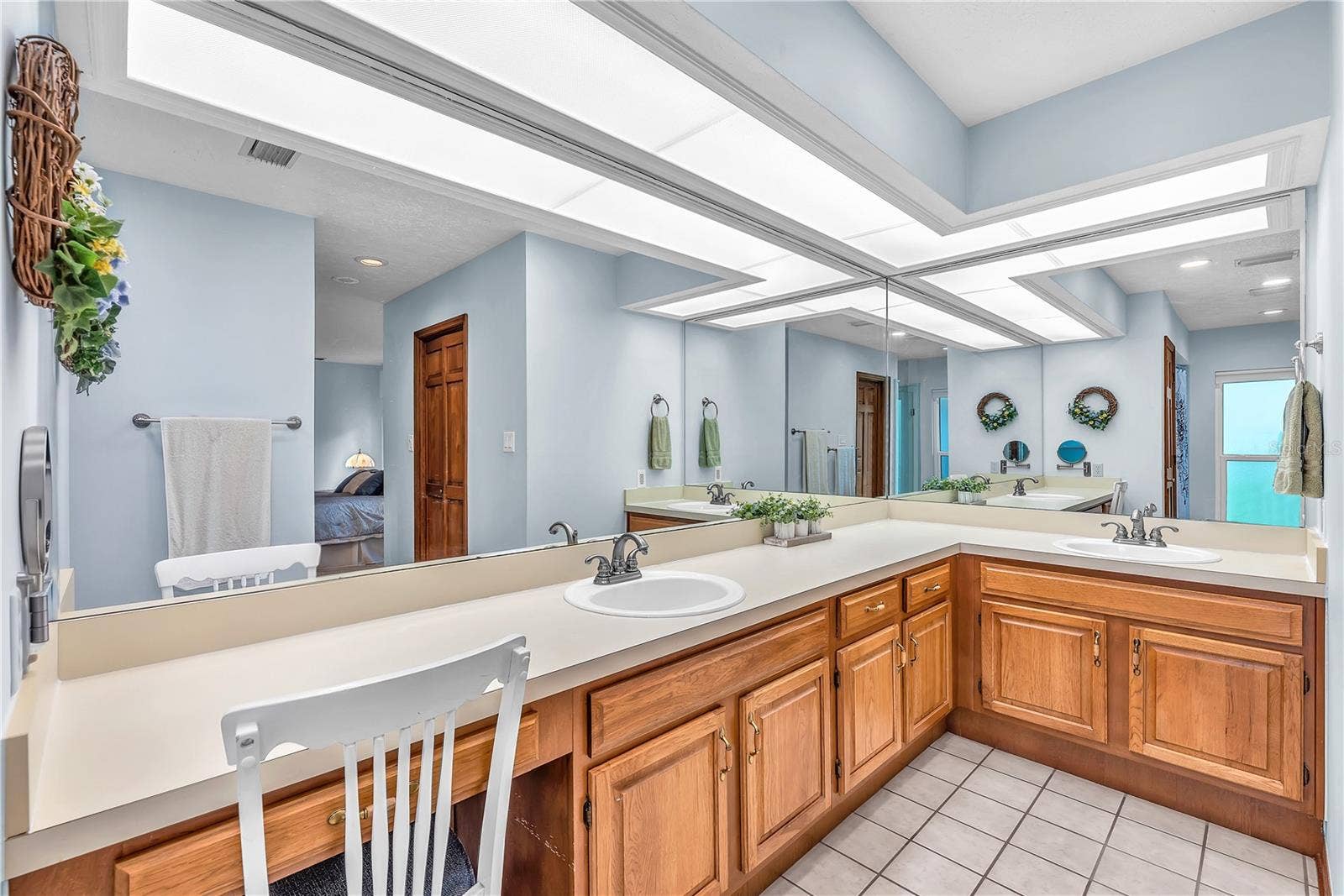 The primary bath features dual sinks, ample storage, and a dedicated makeup vanity for added convenience.
