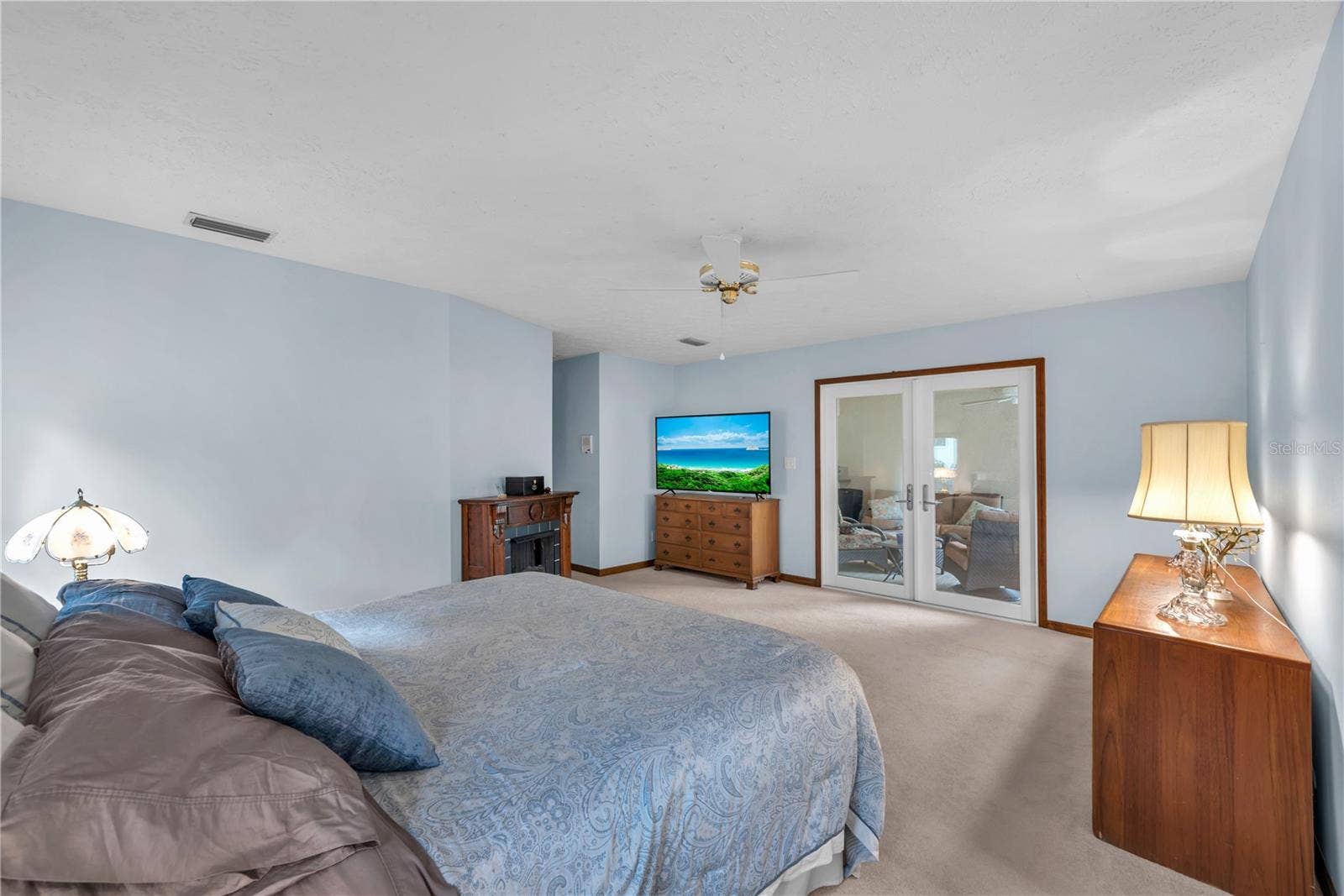 The expansive primary suite is a retreat of its own, complete with French doors opening directly to the screened lanai.