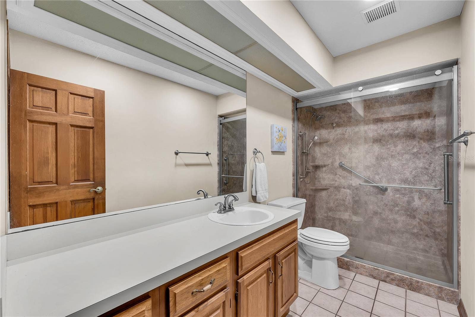 The secondary bedrooms share this hall bathroom with large walk-in shower and vanity with lots of storage.