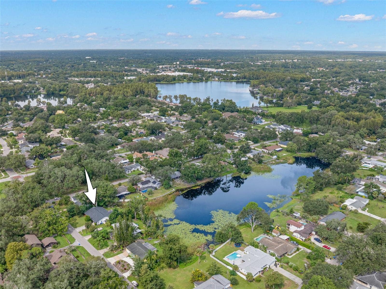 3013 GRAHAM LANE, Tampa, FL 33618 An aerial view highlights the home's setting along a picturesque pond, surrounded by mature trees and established residences in the heart of Carrollwood. Enjoy the tranquility of waterfront living while remaining close to the shopping, dining, recreation, and conveniences of Tampa.