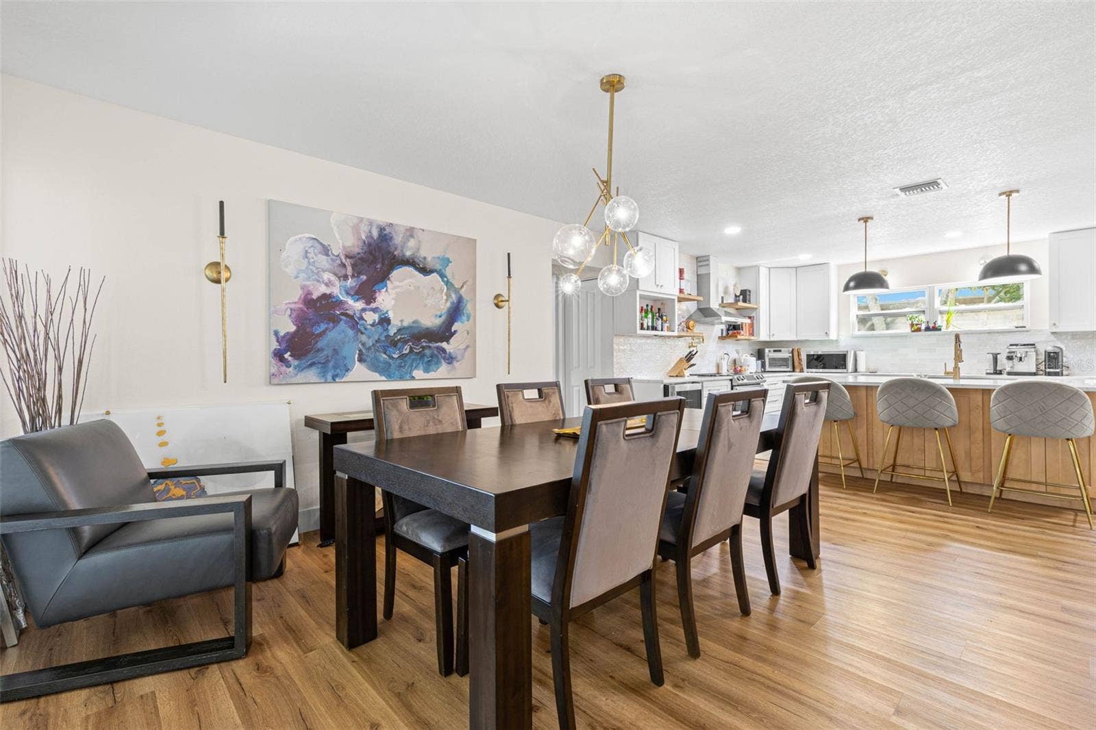 3013 GRAHAM LANE, Tampa, FL 33618 The dining area flows effortlessly into the beautifully updated kitchen, creating an ideal setting for everyday meals and entertaining. A contemporary glass-globe chandelier complements the kitchen's gold fixtures, pendant lighting, and inviting breakfast bar with seating for four.