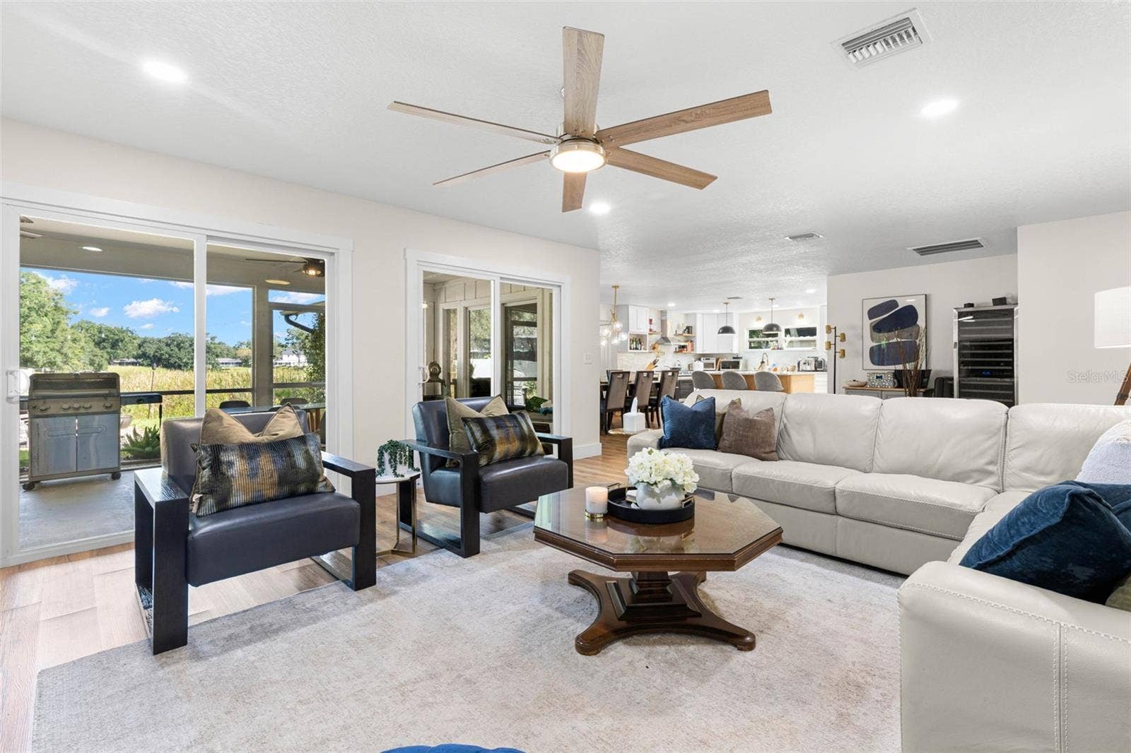 3013 GRAHAM LANE, Tampa, FL 33618 Natural light pours into the living room through sliding glass doors overlooking the backyard, while the open floor plan provides an easy connection to the dining area and kitchen. Step outside to the screened porch for an effortless extension of your indoor living space.