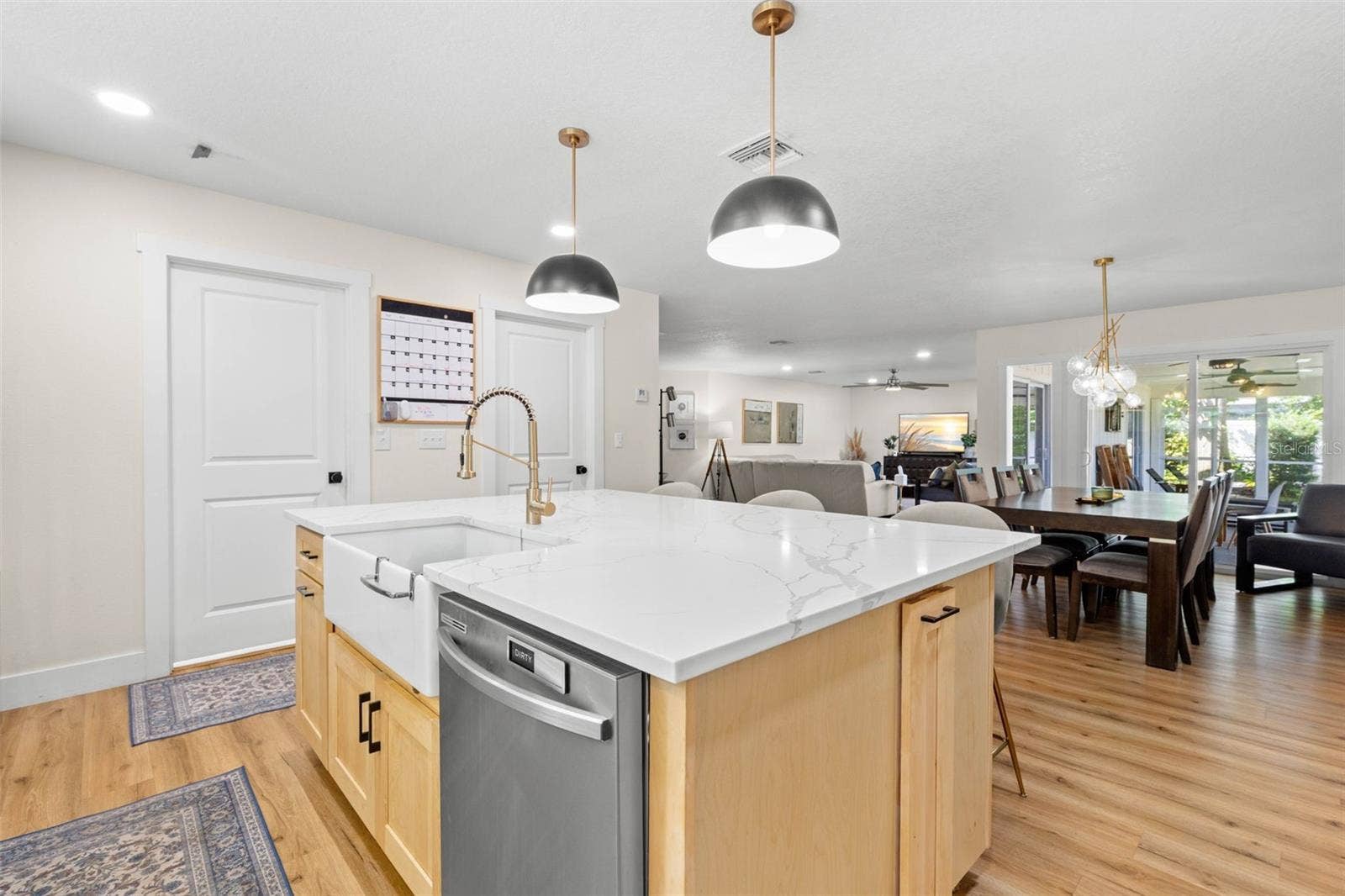3013 GRAHAM LANE, Tampa, FL 33618 Designed with entertaining in mind, the impressive center island features a farmhouse-style apron-front sink, built-in dishwasher, ample workspace, and additional storage. The open layout keeps the kitchen connected to the dining and living areas, making everyday gatherings effortless.
